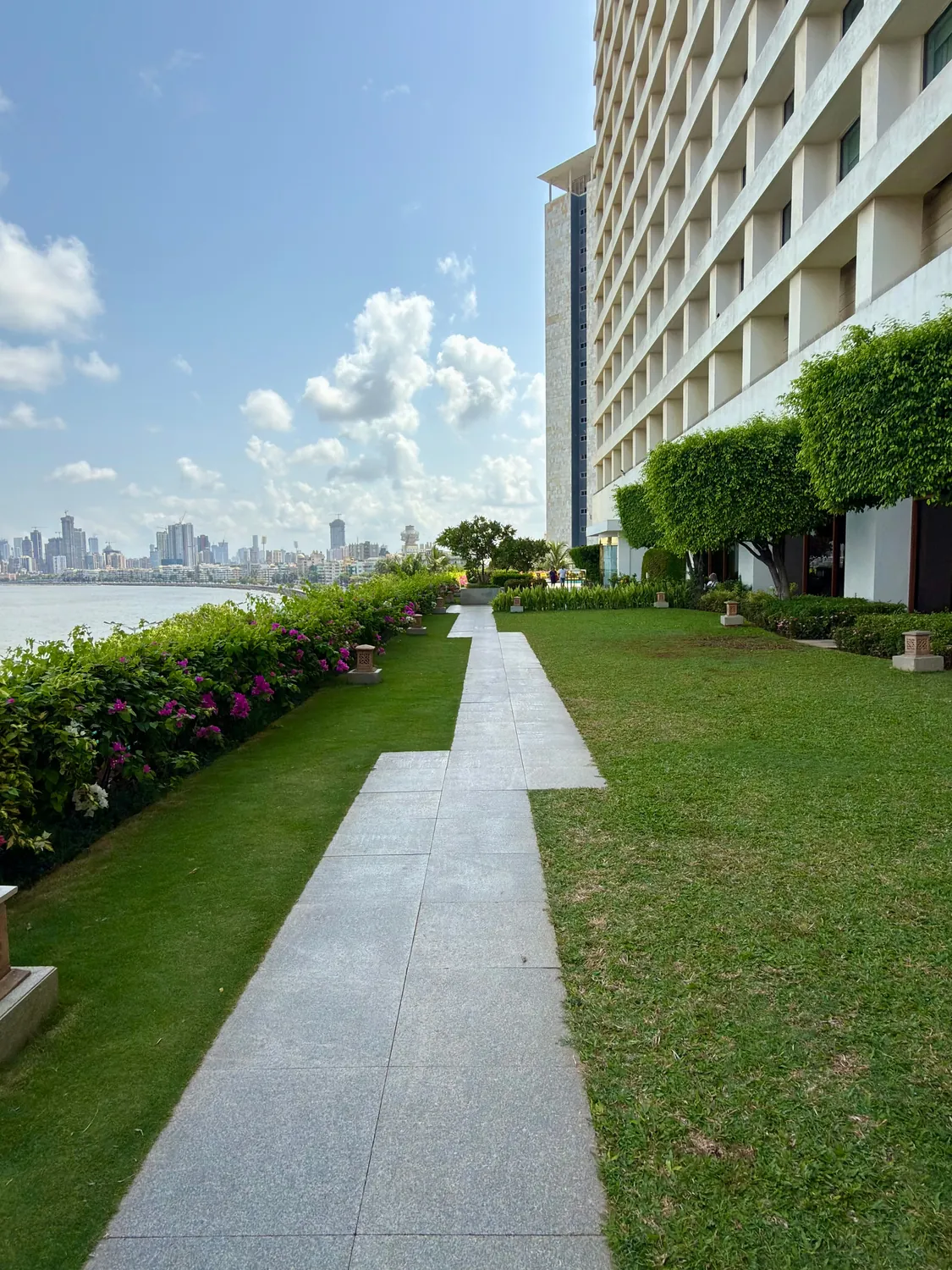 Lawn, granite walk and flowering border beside a waterfront building